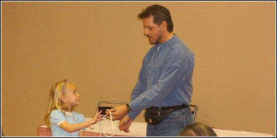 Moriah helps out a magician at a magic club meeting...